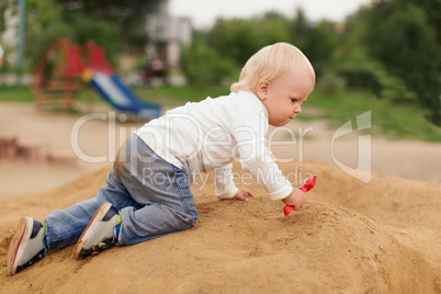 baby boy playing in the sandbox