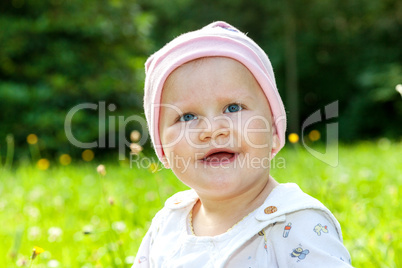 baby with hat on the summer meadow