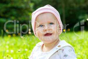 baby with hat on the summer meadow