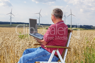 man with laptop in cornfield