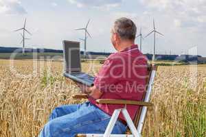 man with laptop in cornfield