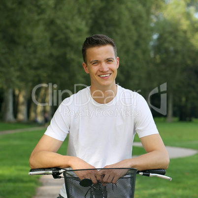 lachender junger mann lehnt an seinem fahrrad