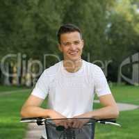 lachender junger mann lehnt an seinem fahrrad