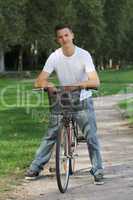 junger mann auf einem fahrrad im park