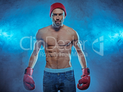 young athletic boxer in a smoky background