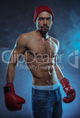 young athletic boxer in a smoky background