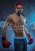 young athletic boxer in a smoky background