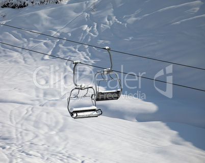 Two chair-lift with snowdrift in sun morning