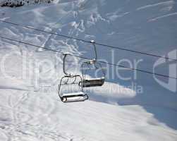 Two chair-lift with snowdrift in sun morning