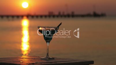 tropical cocktail overlooking a sunset ocean