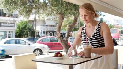 attractive woman taking picture of a pastry on her mobile