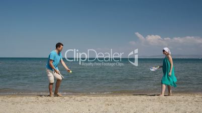 Couple playing bat and ball at the beach
