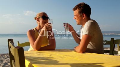 young couple enjoying drinks at the seaside