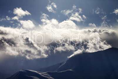 Evening mountain in haze and sunlight clouds