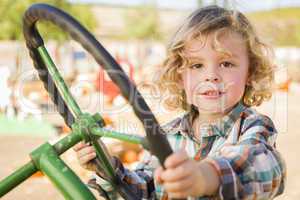 adorable young boy playing on an old tractor outside