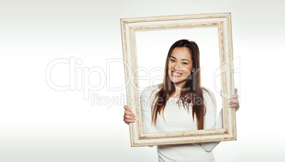 smiling woman holding an old picture frame