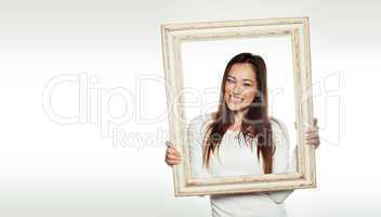 smiling woman holding an old picture frame