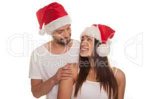 young happy couple wearing santa hats