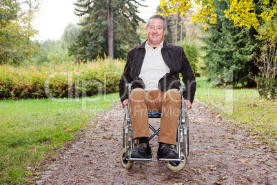 man in wheelchair in autumnal park