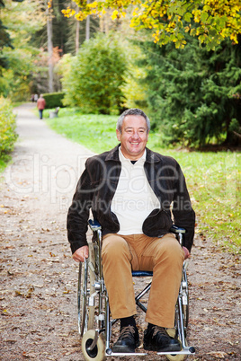 man in wheelchair in autumnal park