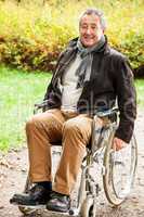 man in wheelchair in autumnal park