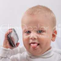 little boy with phone puts out the tongue