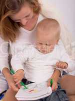 young mother is drawing with her son