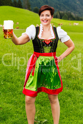 Glückliche junge Frau im Dirndl mit Bier