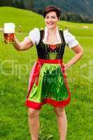 Glückliche junge Frau im Dirndl mit Bier