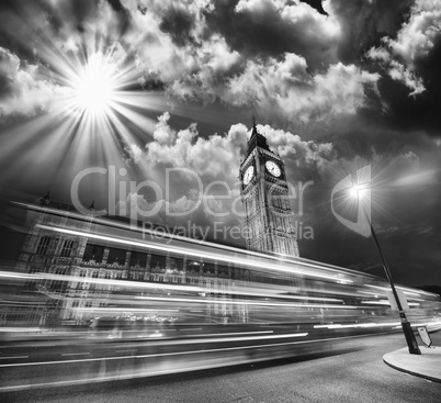 London. Red Bus light trails under famous Big Ben Tower at sunse