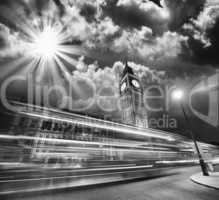London. Red Bus light trails under famous Big Ben Tower at sunse
