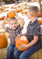two boys at the pumpkin patch talking and having fun.