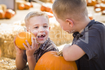 two boys at the pumpkin patch talking and having fun.