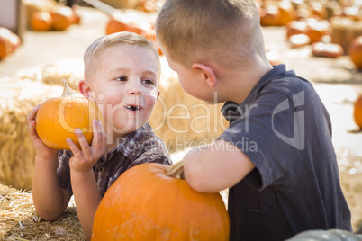 two boys at the pumpkin patch talking and having fun.