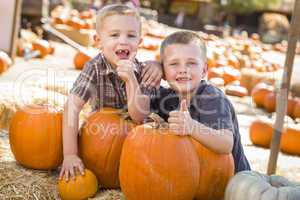 two boys at the pumpkin patch with thumbs up