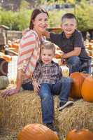 portrait of attractive mother and her sons at pumpkin patch.