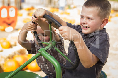 adorable young boys playing on an old tractor outside