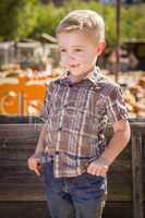 little boy with hands in his pockets at pumpkin patch.