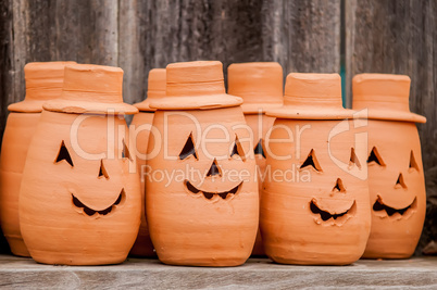 clay pumpkins standing happy near the wood fence