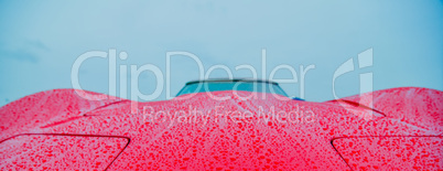 red sports car wet from rain drops