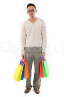 bored asian man holding shopping bags