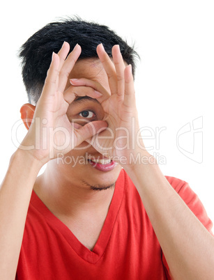 asian man peeping through fingers hole