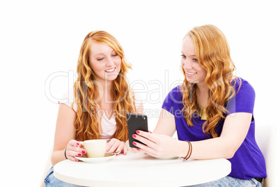 zwei rothaarige glückliche frauen schauen auf ihr smartphone