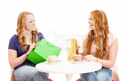 glückliche frauen mit einkaufstüten an einem kaffee tisch