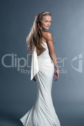 Smiling young girl posing in white cocktail dress