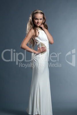 Cute young girl posing in white dress and tiara
