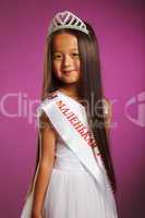 Cheerful little beauty winner posing with tiara