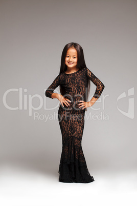 Smiling little girl posing in black lace dress
