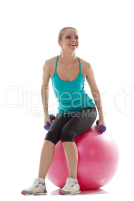 Pretty athlete posing with dumbbells and ball