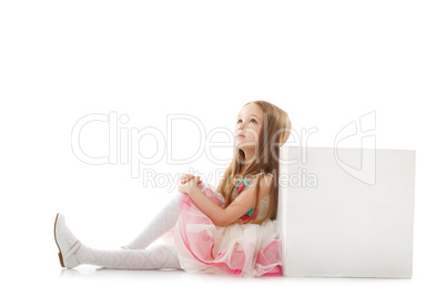 Dreamy little girl posing with cube in studio